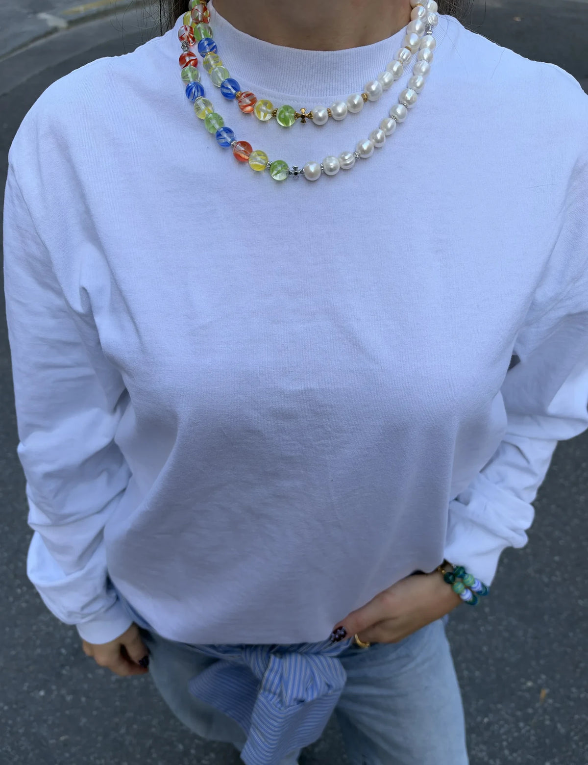 MALCOLM and MALCOLM GOLD necklaces worn layered with a white tee