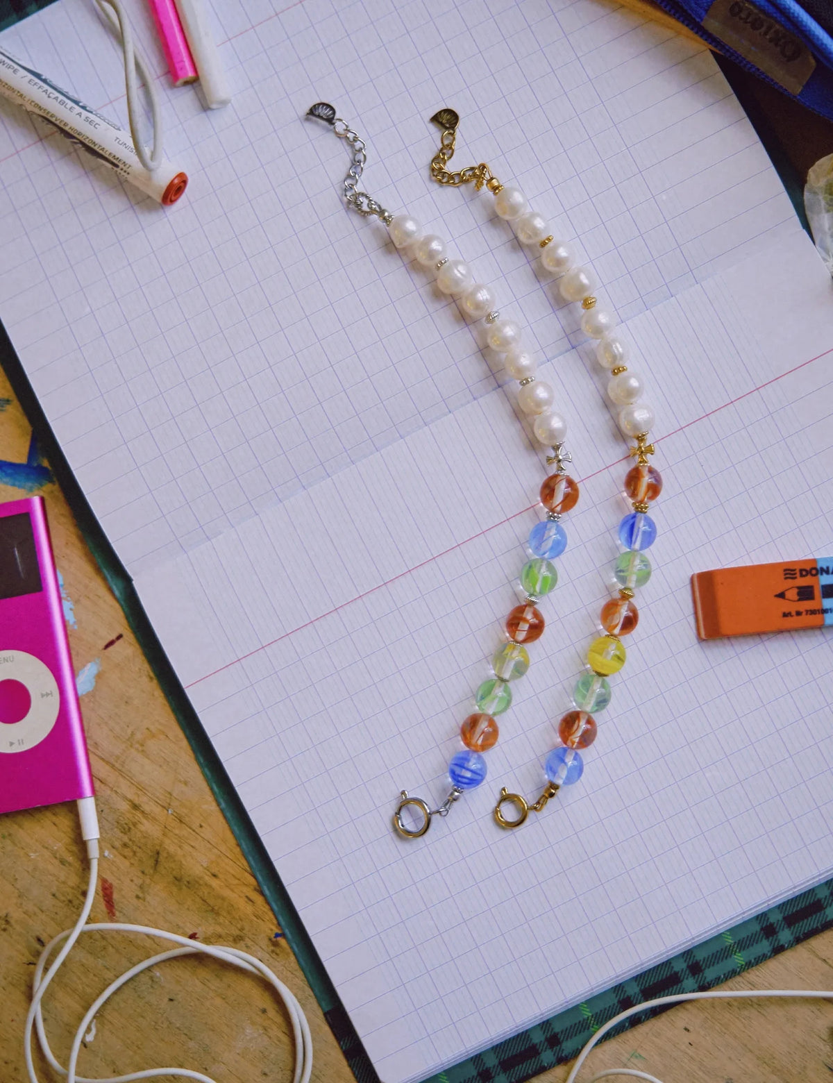 MALCOLM and MALCOLM GOLD bracelets on a school notebook