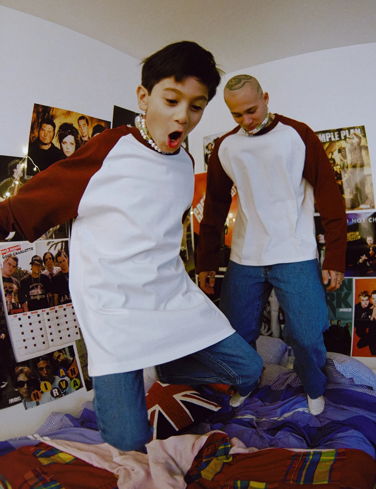 JIMMY necklaces worn by a child and an adult jumping on a bed