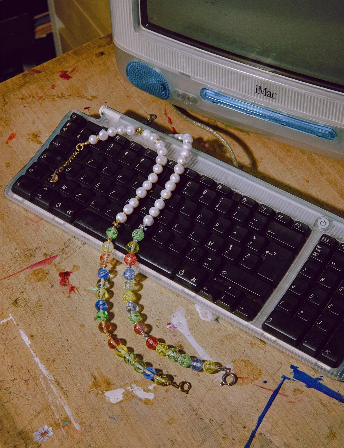 MALCOLM GOLD and DEWEY necklaces on an iMac keyboard