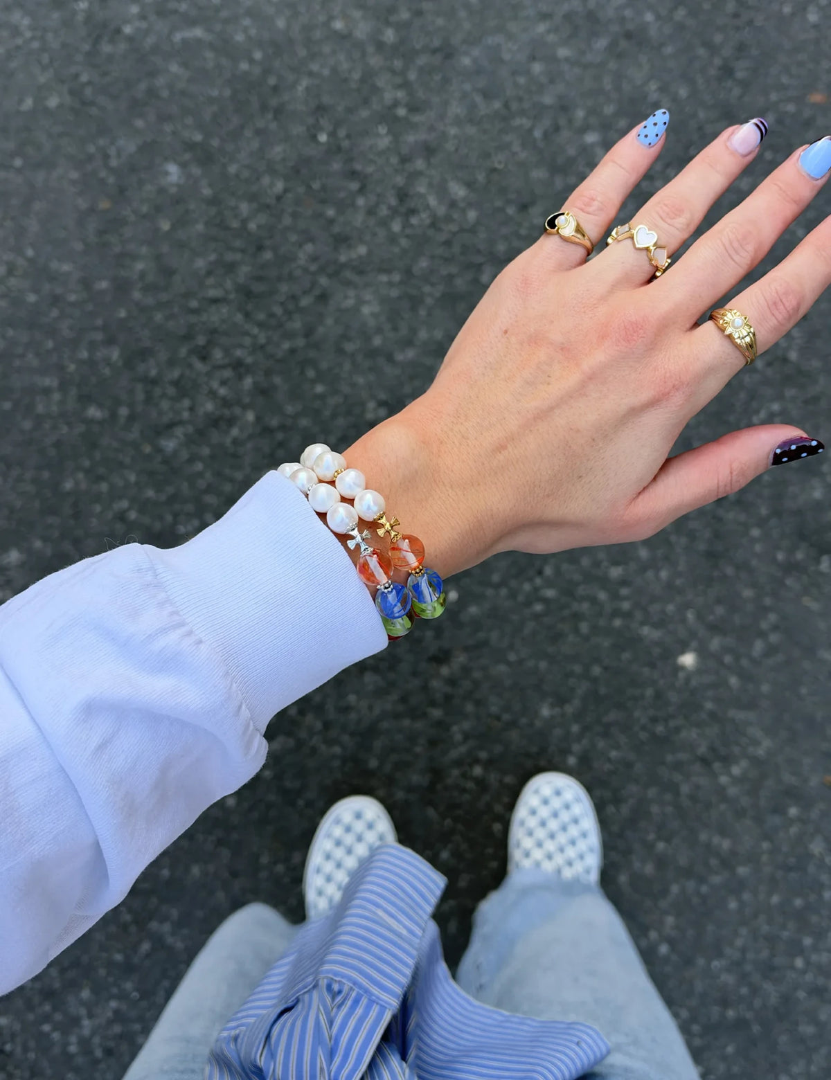 MALCOLM and MALCOLM GOLD bracelets worn stacked with a white sweatshirt