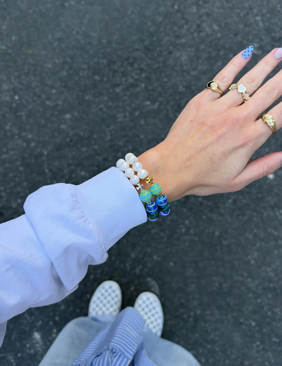 ZACK and ZACK GOLD bracelets worn stacked with a white sweatshirt