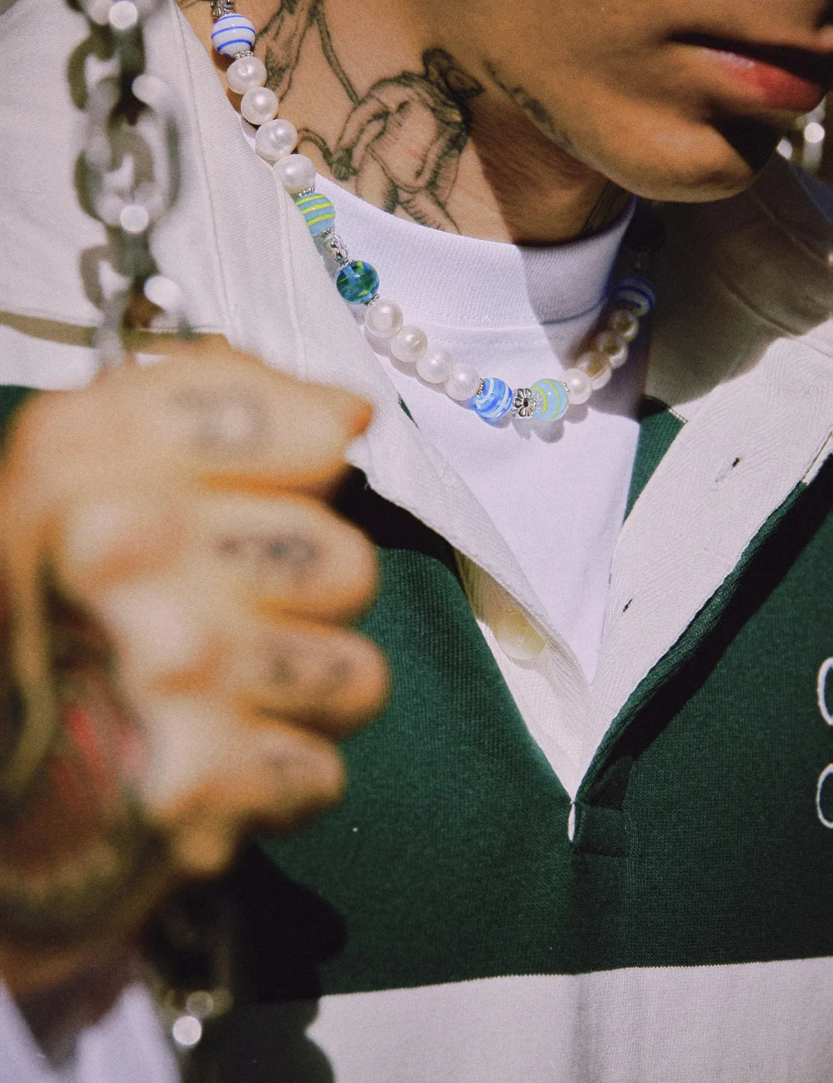 CODY necklace worn with a green rugby shirt